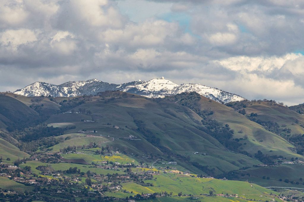 a view of a mountain range with snow capped mountains in the background